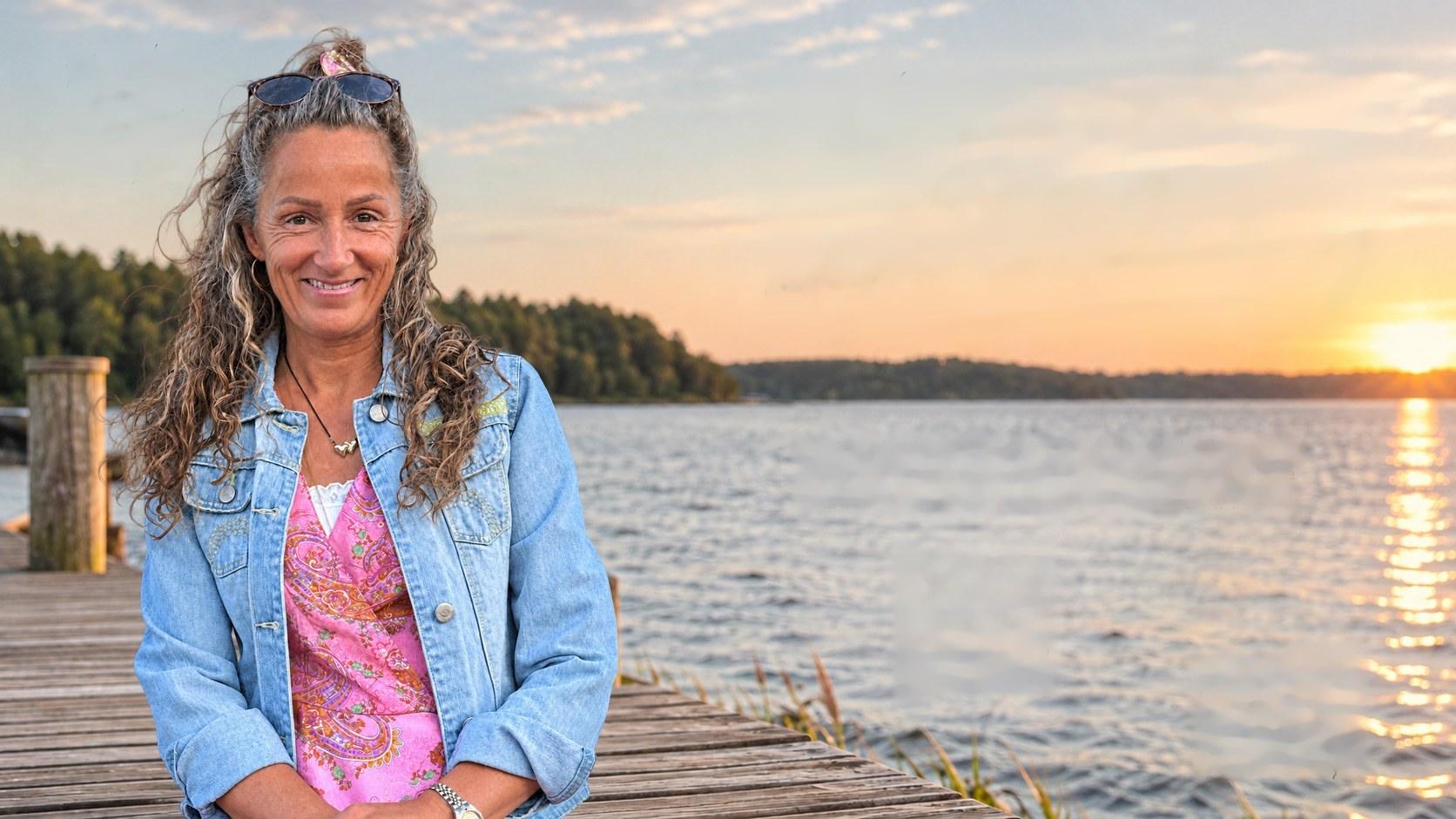 Tina Katja Lund Andersen på en badebro ved vandet i solnedgang